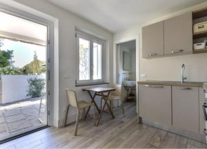 a kitchen with a table and chairs in a room at Bilocale Pianosa - riservato e fresco a soli 10 m dal mare in Pomonte +21 photos