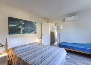 a hotel room with a bed and a painting on the wall at Bilocale Pianosa - riservato e fresco a soli 10 m dal mare in Pomonte
