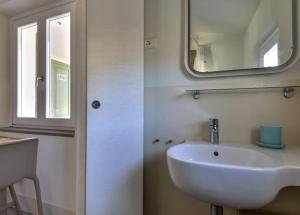 a bathroom with a white sink and a mirror at Bilocale Pianosa - riservato e fresco a soli 10 m dal mare in Pomonte