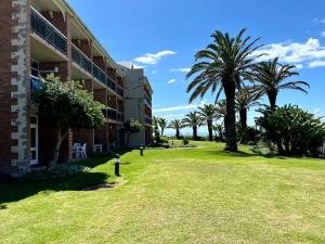Un edificio con palmeras y una boca de incendios. en Brookes at Sea, en Gqeberha