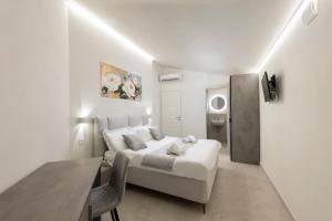 a white bedroom with a bed and a table at B&B IL MORO Boutique Rooms in Siena +15 photos