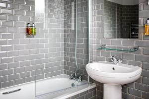 Un baño con lavabo, inodoro y bañera. en Burrator Inn, en Yelverton