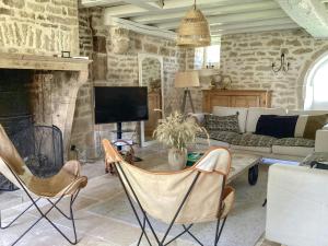 GignyMaison Templière Avec Piscine Près De Chablis的带沙发和壁炉的客厅