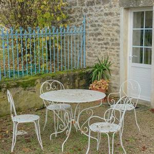 una mesa y cuatro sillas sentadas junto a una valla en Templar House With Pool Near Chablis, en Gigny