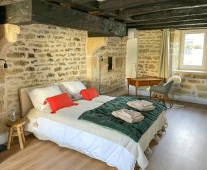 Un dormitorio con una cama grande con almohadas rojas. en Templar House With Pool Near Chablis, en Gigny