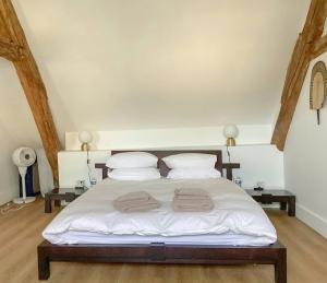 GignyMaison Templière Avec Piscine Près De Chablis的卧室里有一张床，床上放着两条毛巾。 更多22张照片