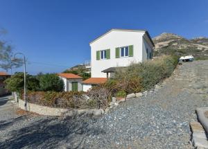 a white house on the side of a hill at Bilocale Pianosa - riservato e fresco a soli 10 m dal mare in Pomonte