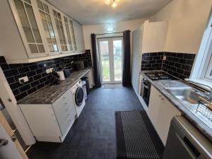 a kitchen with a sink and a dishwasher at Stunning 4 BedHouse Company Workers Welcome, Parking, Wifi, Netfix in Castleford