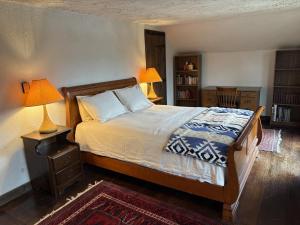 een slaapkamer met een bed met 2 lampen en een tapijt bij Smugglers Trove in Morses Mill