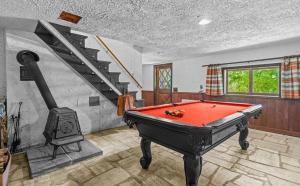 een kamer met een pooltafel en een trap bij Smugglers Trove in Morses Mill