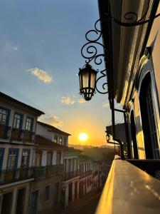 a view of the sunset from a street with a lamp at Pousada Memórias de Minas in Ouro Preto
