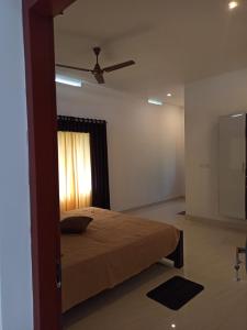 a bedroom with a bed and a ceiling fan at Liyano homestay in Palakkad