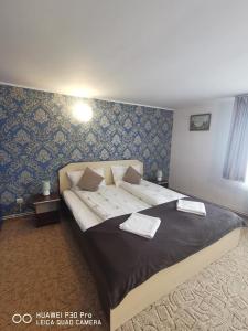 a bedroom with a large bed with two towels on it at Casa Valea Cerbului Busteni in Buşteni