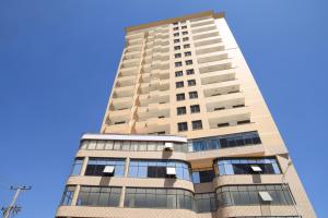 ein hohes Gebäude mit blauem Himmel im Hintergrund in der Unterkunft My Dream Apartments - 4 miles from Bole International Airport in Addis Abeba