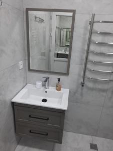 un baño con lavabo y espejo en Уютный дом для семьи AL INN, en Qusar