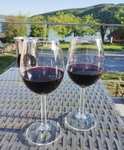 two glasses of red wine sitting on a table at Hollandia Domasa - Nová Kelča, Prešovský kraj in Kelča