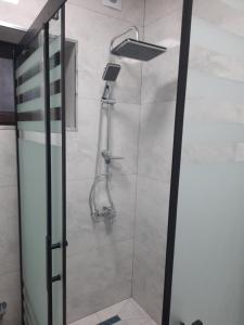 una ducha en un baño con puerta de cristal en Уютный дом для семьи AL INN, en Qusar