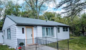 een klein wit huis met een zwart dak bij Honey Pot House in Novi