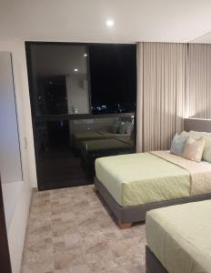 una habitación de hotel con dos camas y un sofá en Brand New Modern Apartment-Suite Meters from the Beach, en Gaira