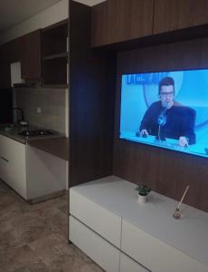 Una pantalla de televisión con un hombre en ella en una cocina. en Brand New Modern Apartment-Suite Meters from the Beach, en Gaira