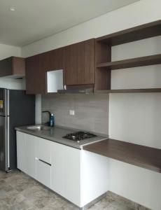 Una cocina con gabinetes blancos y un horno de estufa. en Brand New Modern Apartment-Suite Meters from the Beach, en Gaira