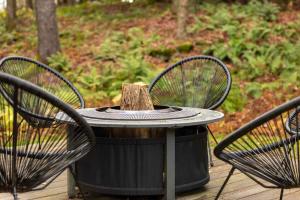a table with two chairs and a trash can at Private Chalet with Fire Pit Deck and Large Yard in Roscoe