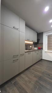 a kitchen with white cabinets and a wooden floor at Martin Ferienhaus in Burg bei Magdeburg