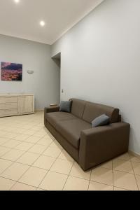 un soggiorno con divano marrone in una camera di House by the station -Close to Oplonti Ruins a Torre Annunziata