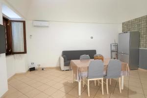 una cucina con tavolo, sedie e frigorifero di House by the station -Close to Oplonti Ruins a Torre Annunziata