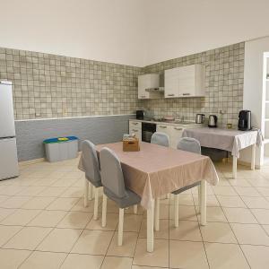 una cucina con tavolo e sedie e una cucina con elettrodomestici bianchi di House by the station -Close to Oplonti Ruins a Torre Annunziata