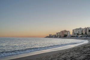 una playa con edificios en la distancia y el océano en Vistas al Mediterráneo - 4 Huéspedes, en Fuengirola