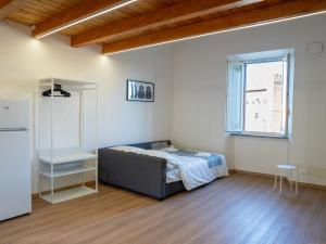 a bedroom with a bed and a refrigerator in it at CAERE RoGi House in Cerveteri
