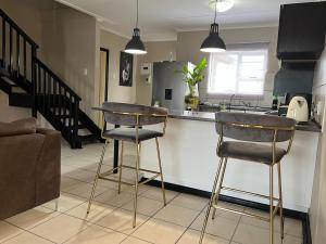 a kitchen with two bar stools at a kitchen counter at The Grey Ivory in Port Alfred
