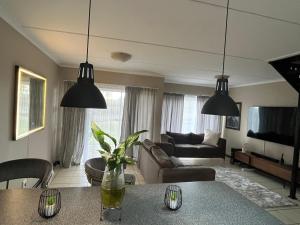 a living room with a table and two pendant lights at The Grey Ivory in Port Alfred