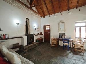 Traditional Greek Cottage في Palaiókastron: غرفة معيشة مع أريكة وطاولة وموقد