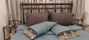 a bed with a metal headboard with pillows on it at Ariadnis Apartment in Artemida