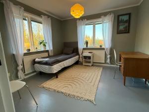 Un dormitorio con una cama y una mesa y ventanas. en Cosy comfy house in the countryside, en Borgvattnet