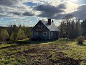 una casa azul con un coche aparcado en el patio en Cosy comfy house in the countryside, en Borgvattnet