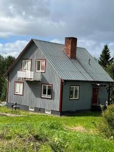 una casa roja y blanca con chimenea en Cosy comfy house in the countryside, en Borgvattnet