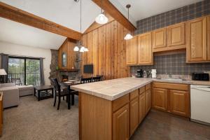 a kitchen with wooden cabinets and a dining room at Beaver Village Unit #0834 in Winter Park