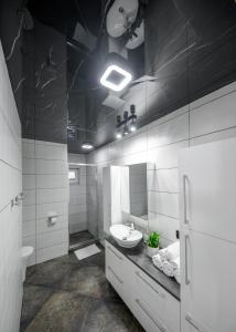 a white bathroom with a sink and a mirror at APARTAMENTY z GÓRSKIM KLIMATEM in Duszniki Zdrój