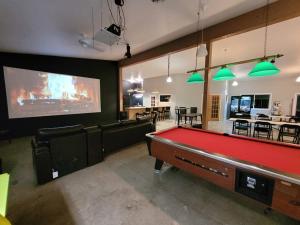 een kamer met een pooltafel en een groot scherm bij Petit chalet au bord du lac in Shefford