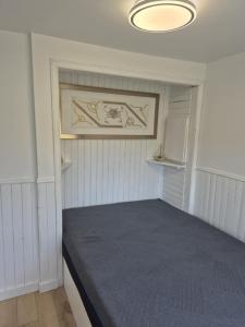 een kleine slaapkamer met een bed in een kamer bij Petit chalet au bord du lac in Shefford