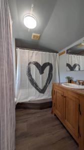 een badkamer met een gordijn met een hart erop getekend bij Petit chalet au bord du lac in Shefford