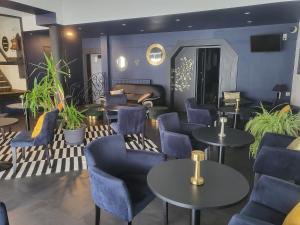 una sala de espera con sillas y mesas azules en Le Patio De La Dordogne, en Souillac