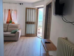 a living room with a couch and a sliding glass door at Villa Primula in Molveno