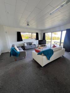 a living room with two couches and a couch at Coopers Haven- Beachfront House in Coopers Beach