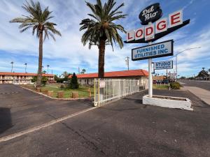 een bord voor een motel met palmbomen en een gebouw bij Del Rio Hotel O near Mesa Downtown in Mesa