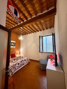 a bedroom with a bed and a chair in a room at BACCANO Guest House in Montepulciano