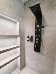 a shower with a black shower head in a bathroom at Hostal La Casa Del Escudo in Trujillo +2 photos